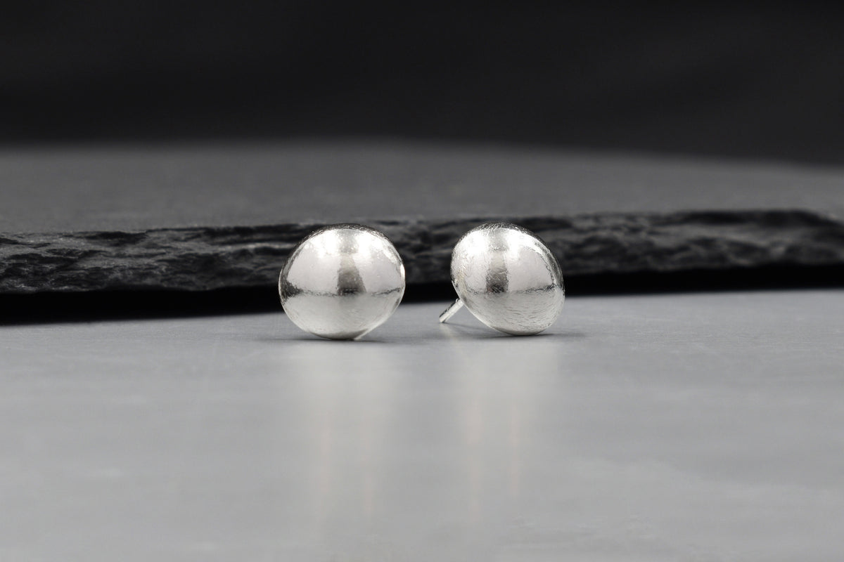 Solis Stud Earrings in pure silver showing a soft sculptural dome silhouette.