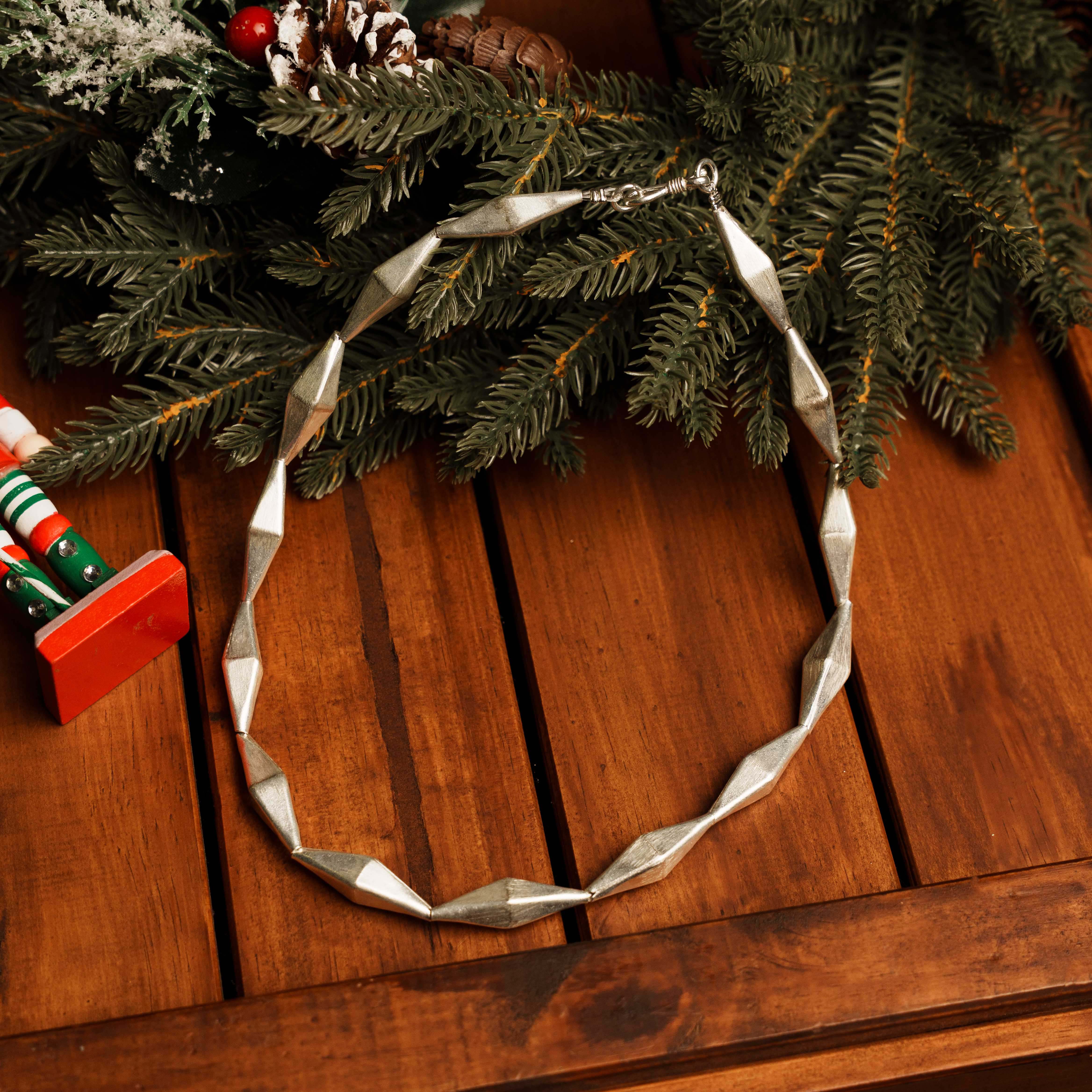 Thalia Necklace in pure silver showing faceted, twisted segments with a bold sculptural silhouette.