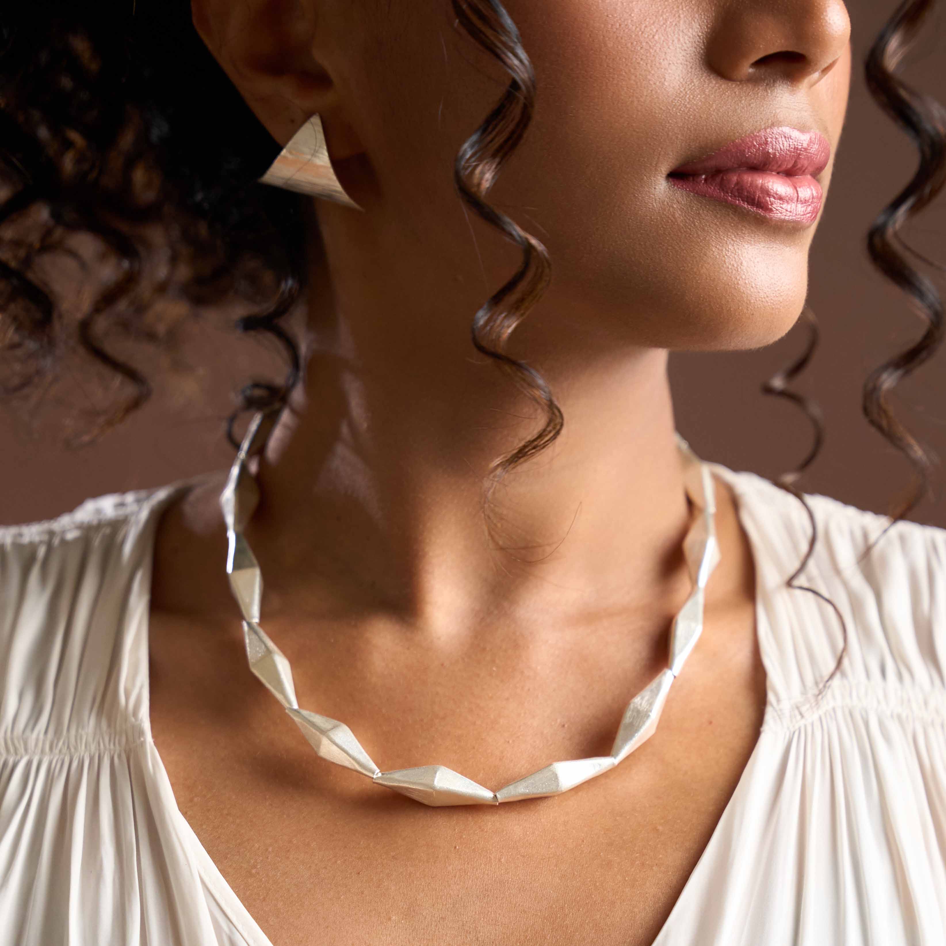 Model wearing the Thalia Necklace, a sculptural pure silver statement necklace for everyday styling.
