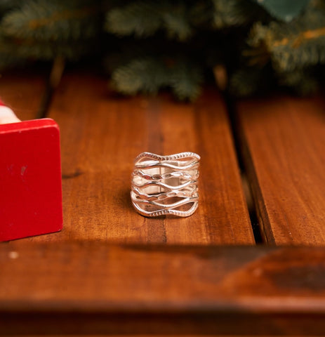 Onda Ring in pure silver showing layered wavy bands in mixed textures.