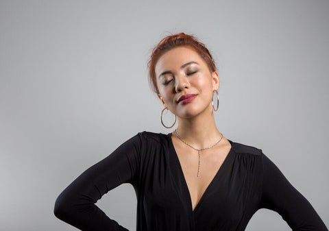 Model wearing classic large thick hoops with black top and lariat necklace