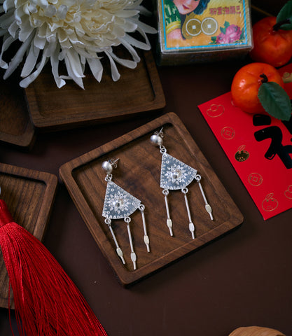 Linya Earrings in pure silver showing hand-textured geometric form with slender dangling elements.