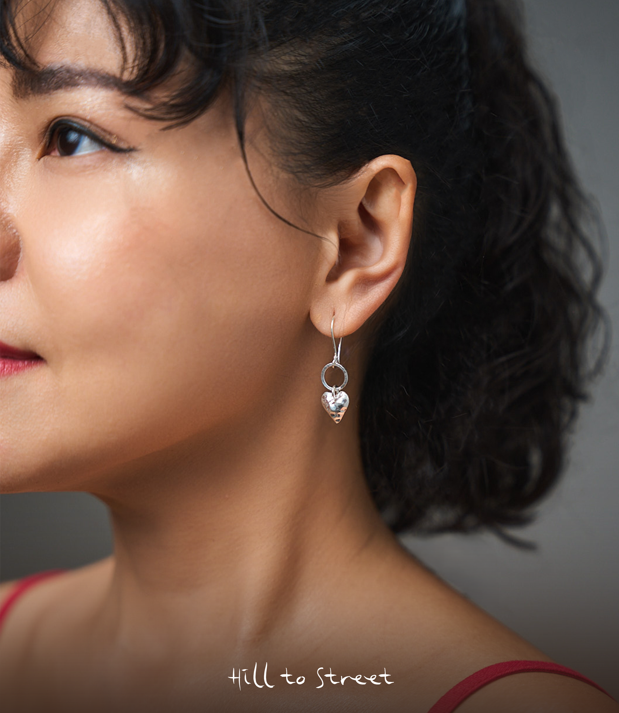 Model wearing Elin Heart Drop Earrings, a minimalist pure silver drop earring for everyday styling.