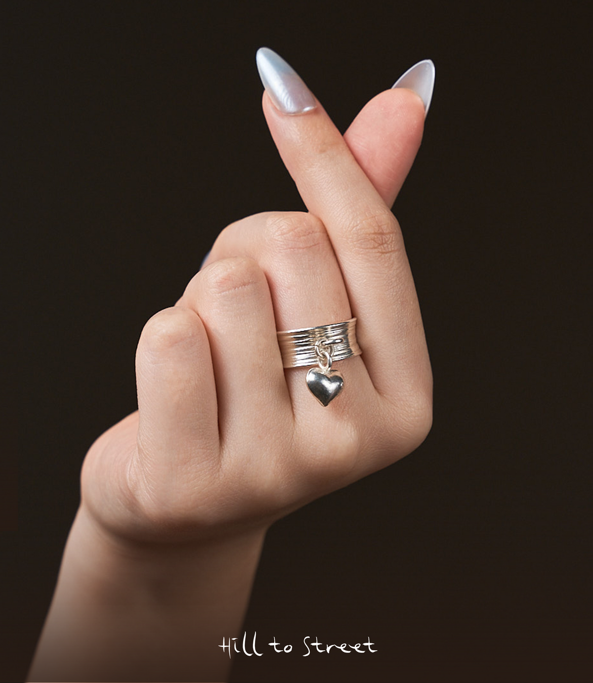 Model wearing Heart Charm Band, a playful pure silver heart charm ring for everyday styling.