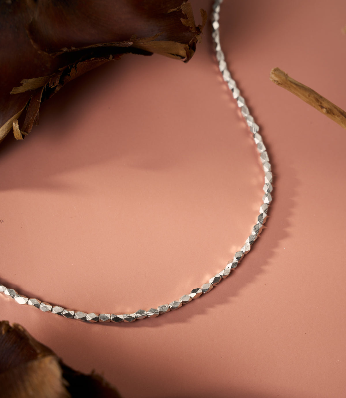 The Livia Facet Necklace in pure silver featuring finely cut facet details on a delicate silver chain.