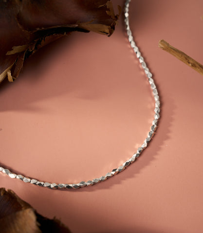 The Livia Facet Necklace in pure silver featuring finely cut facet details on a delicate silver chain.