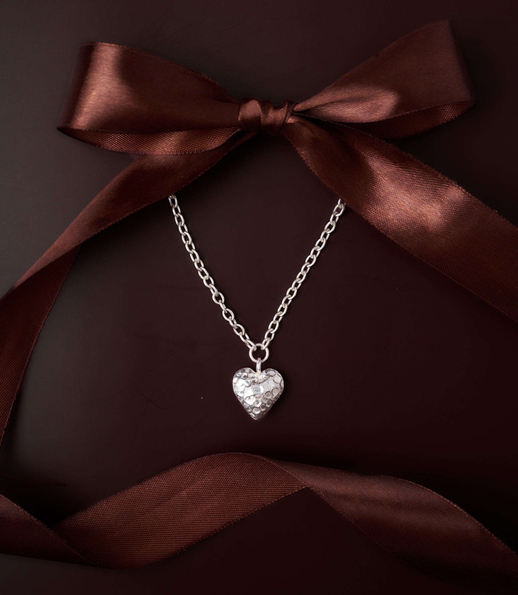 Mira Heart Necklace in pure silver showing softly hammered heart pendant on a delicate chain.