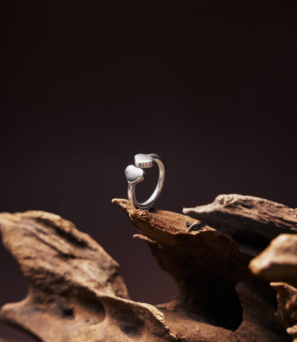 Double Heart Ring in pure silver showing two side-by-side sculpted hearts on a slim band.
